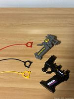 Two Beyblade launchers and three ripcords on tabletop