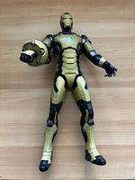 Full view of Iron Man figure lying flat, showing overall condition and attached launcher