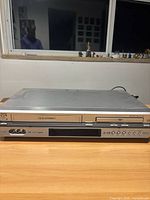 Front view of JVC HR-XVC27U VHS DVD combo deck on table
