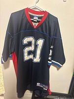 Front of navy Reebok Buffalo Bills #21 jersey hanging, shows collar tag and front numerals