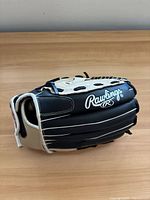 Side view of Rawlings black and cream glove