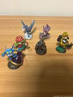 Six Skylanders figures arranged on wooden surface