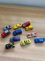 Overview of all eleven toy vehicles on wooden surface