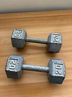 Two 20 lb hexagonal dumbbells on wooden surface