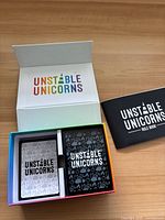 Open box showing two card decks and rulebook