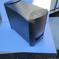 Black Bose Acoustimass Cinemate subwoofer unit with visible front bass port and logo.