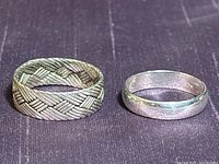 Both sterling silver rings side by side, showing basket-braided and plain band designs