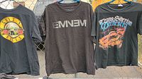 Front view of all three band T-shirts hanging