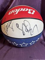 White panel with two player signatures in black ink on tri-color Baden basketball