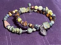 Full view of two-coil gemstone memory-wire bracelet on purple background