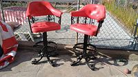Both red vinyl bar stools side by side showing overall design