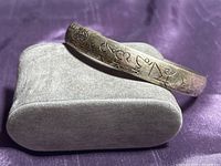 Full view of cuff bracelet resting on display pillow