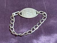 Full view of bracelet front showing oval tag and chain