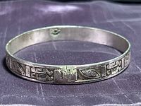 Full view of Taxco sterling silver bangle showing exterior glyph pattern