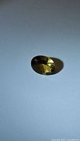 Photo of natural oval cut champagne citrine gemstone showing its yellow-golden color and oval faceting.