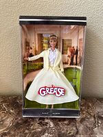 Front view of the Barbie doll in original box showing Grease branding and backdrop