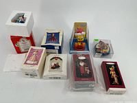 Group of 8 assorted Christmas ornaments in original boxes and packaging, various themes and characters.