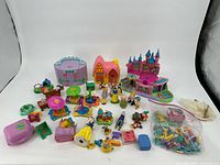 Overview of all items in the lot showing various playsets and figurines arranged on a white backdrop.