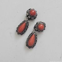 Full view of the pair of coral and sterling silver clip-on earrings with dangle design