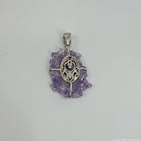 Front side of the pendant showing sterling silver ornate overlay on amethyst druzy quartz.