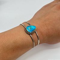 Sterling silver and turquoise cuff bracelet worn on wrist showing fit and style.