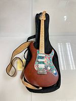 Full view of Yamaha Pacifica electric guitar laying on soft case with strap attached.