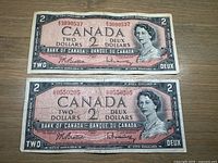Front view of both 1954 $2 banknotes showing serials, portrait, signatures