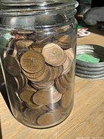 Jar filled with numerous bronze pennies
