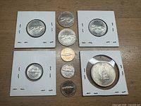 Group view of all nine 1967 Canadian Centennial coins including half dollar (in holder), quarters and dimes