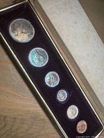 Full boxed set of six coins in purple felt insert