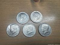 Obverse side of all five Kennedy half dollars, showing years 1971, 1971, 1972, 1974, 1977