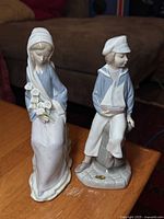 Front view of both Lladro figurines showing design and colour