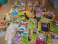 Wide view of numerous Pokémon cards spread and stacked on table