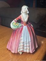 Front view of Royal Doulton Janet figurine showing full gown and basket