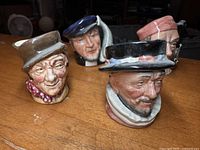 Four Royal Doulton miniature Toby mugs grouped on table