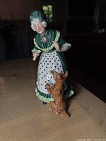 Front view of porcelain figurine showing Old Mother Hubbard and dog