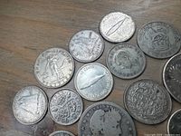 Oblique view of mixed coins showing Canadian centennial dimes, Standing Liberty quarter, Netherlands 25 cents, Barber quarter obverse