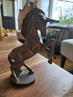 Side view of the solid brass unicorn statue showing rearing pose and horn detail.