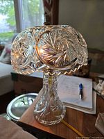 Full view of lead crystal boudoir lamp showing intricate hand-cut spiral and starburst designs on shade and base, scalloped edges on shade, cord visible