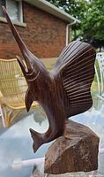 Left side view of the vintage solid wood sailfish statue showing detailed carved fins and open mouth.