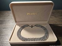 Vintage rhinestone choker necklace displayed in a beige cushioned box with 'PEGASUS' branding on the lid interior.