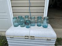 All eight aqua mason jars on white cooler