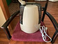 Humidifier assembled on chair showing overall appearance, power cord and nozzle