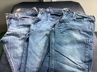Three pairs of blue Levi's jeans laid out