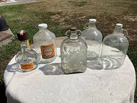 Group shot of five glass jugs and bottles on table