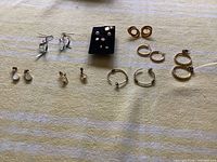 Overview of all earrings laid out on cloth