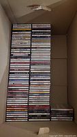 Stack of over 100 country music CDs inside carton