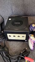Front view of Nintendo GameCube console with controllers and cables in frame