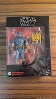 Front view of sealed Star Wars Black Series Heavy Infantry Mandalorian figure and accessory in box