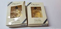Two boxed bottles of Calvin Klein Obsession Eau de Toilette, 0.5 fl oz (15 ml) each, front view showing packaging and bottle inside.